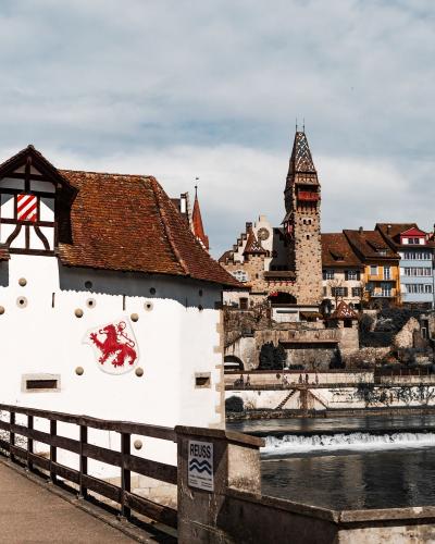 Charming view of Bremgarten castle and historic buildings by the River Reuss in Switzerland.