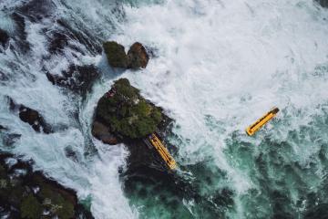 Stunning aerial view of Rhine Falls, Switzerland's majestic waterfall, captured with tour boats navigating through.