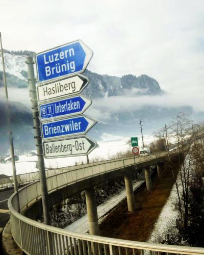 Road signs in snowy Swiss landscape with foggy mountains in the background. Captured near Sachseln, Switzerland.